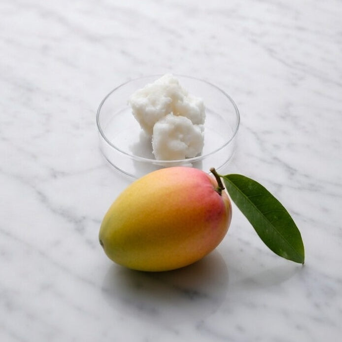 Mangosmør, frisk mango og blade på marmoroverflade